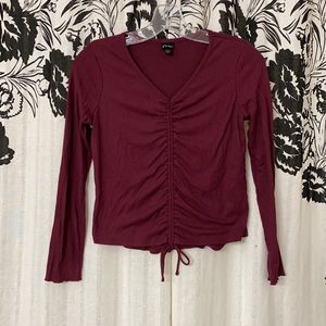Cute maroon knit shirt with draw string through center and tied off at bottom